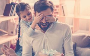 Hija entregándole a su papá un regalo