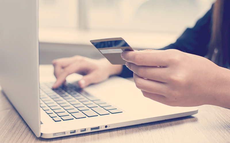 Manos de una mujer pagando con tarjeta de crédito una compra en internet