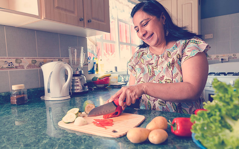 Mamá colombiana feliz cocinando comida saludable