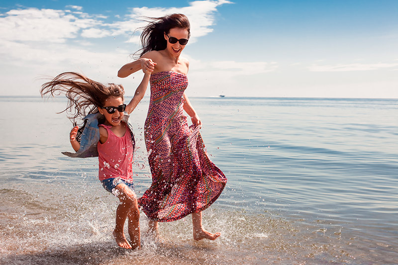 madre e hija disfrutrando en la playa