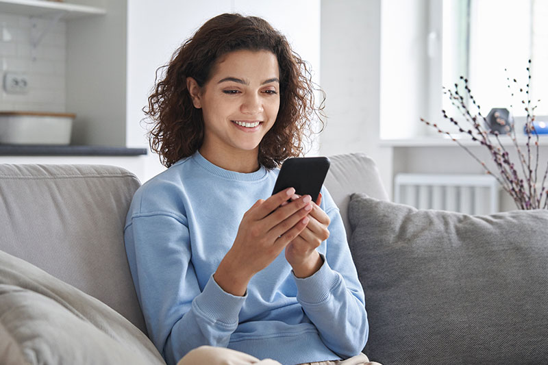 adolescente feliz sosteniendo un celular