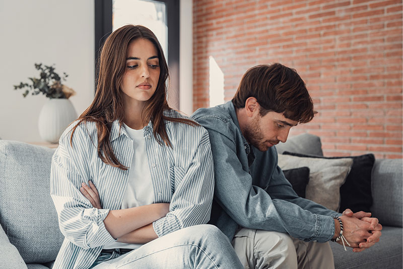 dama sentada en el sofa hablando con un hombre