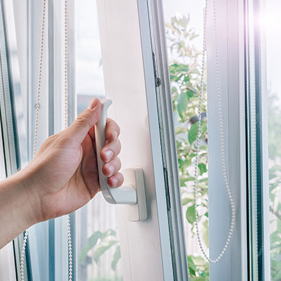 persona abriendo una ventana