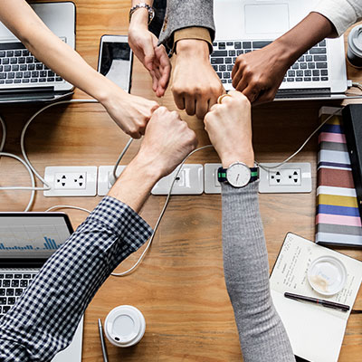 Equipo de trabajo unido tras diseñar proyectos empresariales exitosos y planes de acción.