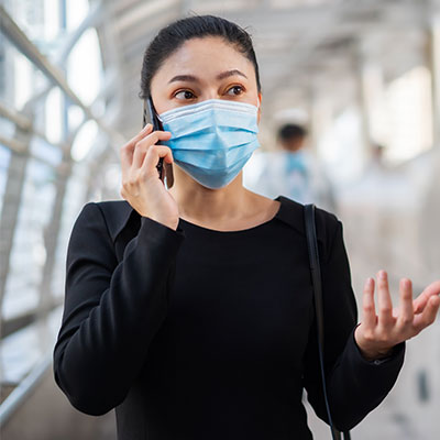 Mujer usando tapabocas en lugar público como medida de prevención para evitar el contagio de tuberculosis.